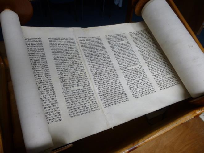 The Torah Scroll is written in Hebrew and by hand. When you read Hebrew, you read it from right to left. The Torah Scroll is written on parchment (animal skin) and by hand.