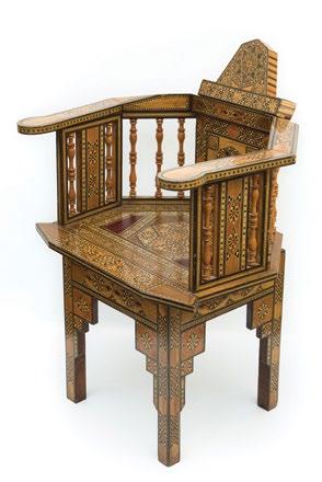 A Syrian Gondola back Mosaic Marquetry Armchair كرسي سوري ذو ذراعني من الطراز العثماني بظهر جندول من اخلشب املطعم بالعاج والصدف of exotic and dyed woods, geometrically decorated overall.