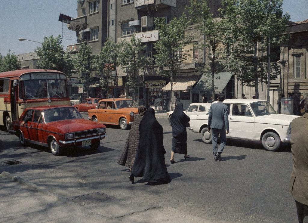 A street scene showing pedestrians threading their way between bumper-to-bumper traffic, June 16, 1970, Tehran, Iran.