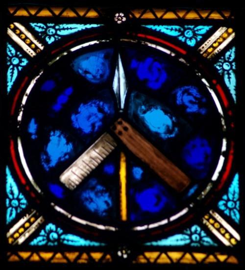 St. Thomas - The window of Thomas shows a vertical spear and a carpenter's square. The square refers to him as a builder or carpenter.