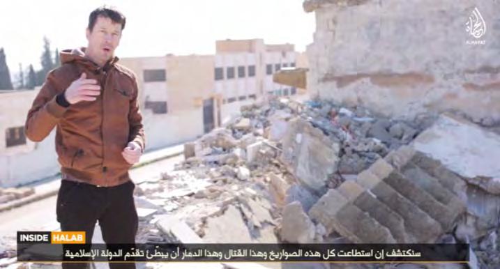 22 John Cantlie against the background of a ruined building allegedly located in Aleppo, which