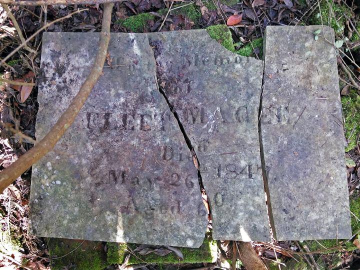 The remains of the headstone for Fleet Magee sat in scattered pieces on top of a huge pile of moss covered red bricks.