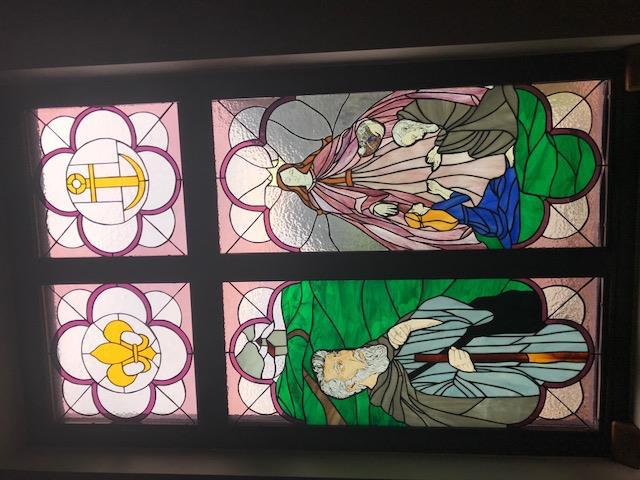 The second window represents Shelter the Homeless. On the left Saint Benedict Joseph Labre' provides shelter to homeless youth.