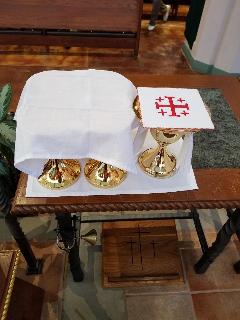 Place the Chalices and the ciboria on the credence table and cover the Chalices with a red or yellow cross corporal.