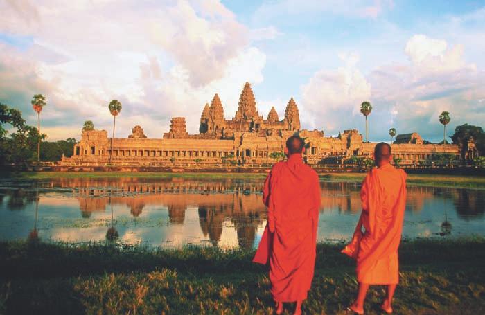 Buddhist monks view a temple at Angkor Wat in Cambodia.