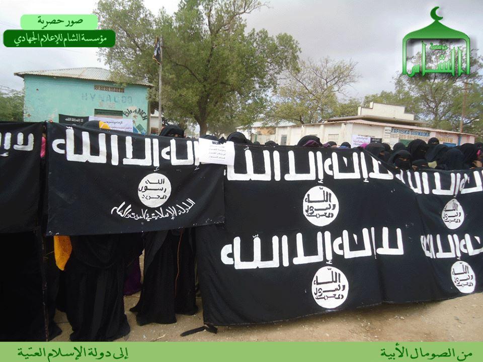 ash- Sham on it. Somali women in niqabs display ISIS banners.