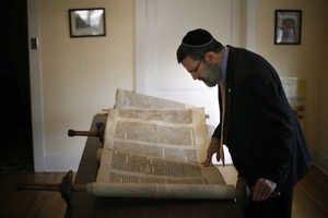 its orgins in Rabbi Moshe Druin evaluates a Torah at Temple Shalom in Yakima, Wash.