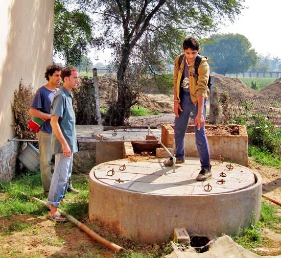 Sudhanshu showing two western volunteers Amrit Sagar s biogas system for transforming cow manure into cooking gas. Three months of the year Dr.
