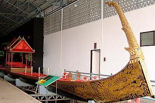 The Ekachai class barge with the horn of a mythical horned dragon or hera on the bow. The dragon's head and body are painted on the hull of the barge.