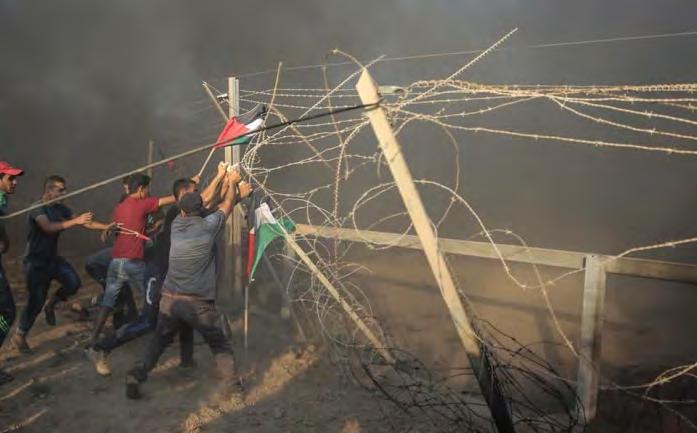 page, August 17, 2018). Right: Gazans burn tires near the security fence.