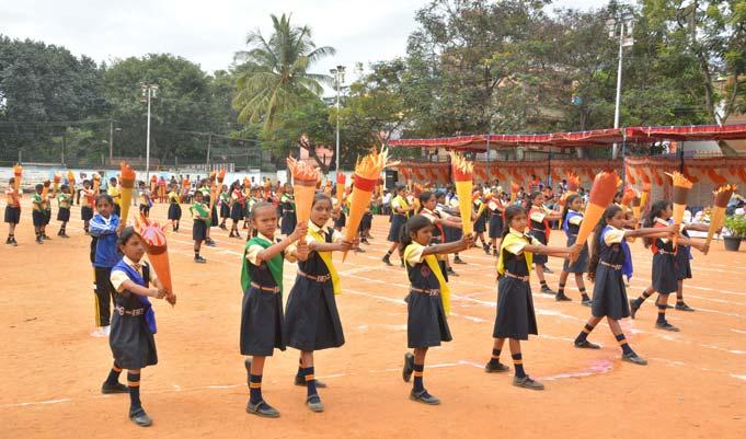 Students participate in the Olympic Torch Formation. a report of the school s sports regimen, sports being an integral part of the school s curriculum.